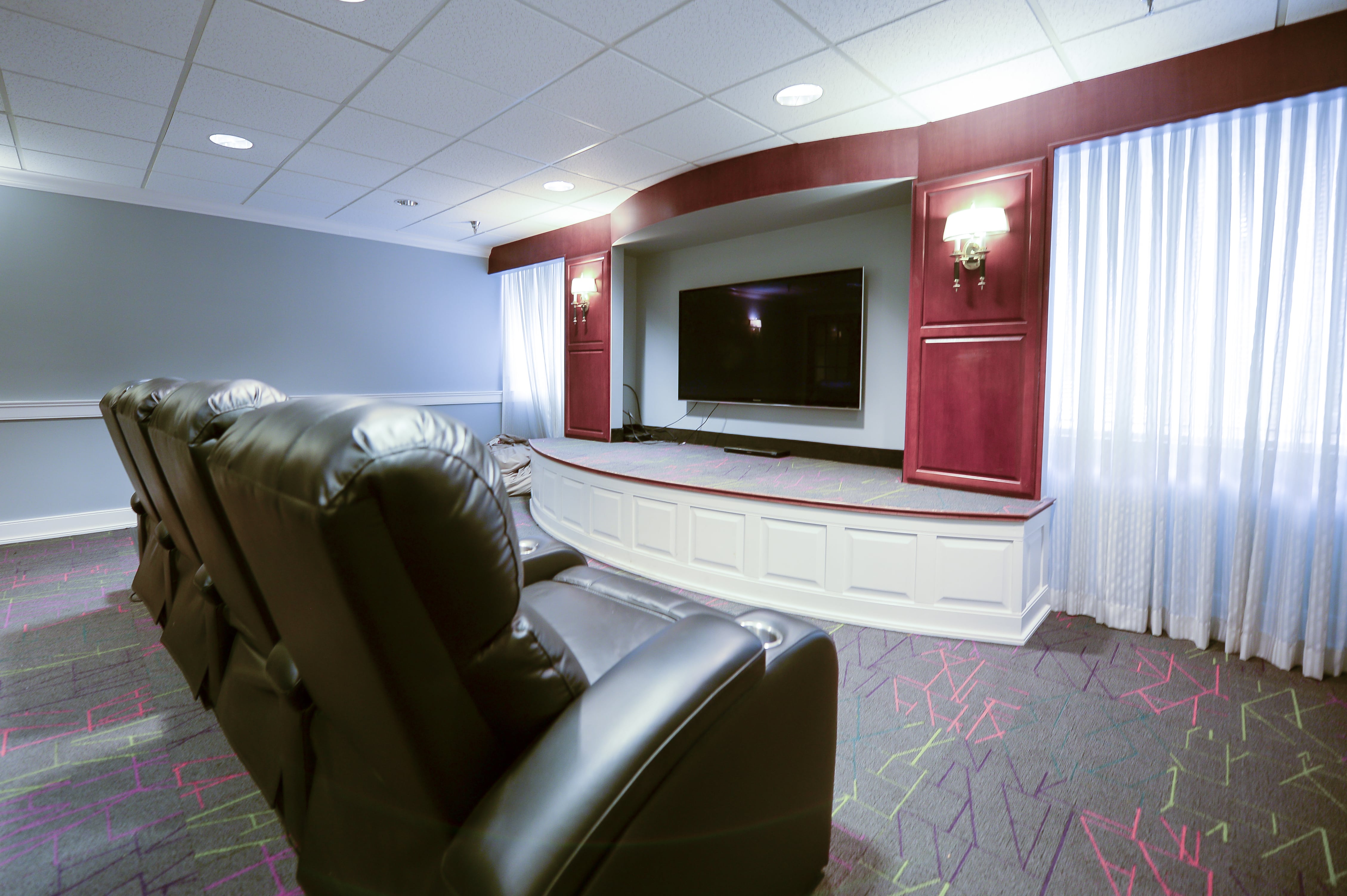 Residence on Fifth Movie Lounge - recliner chairs and a large tv